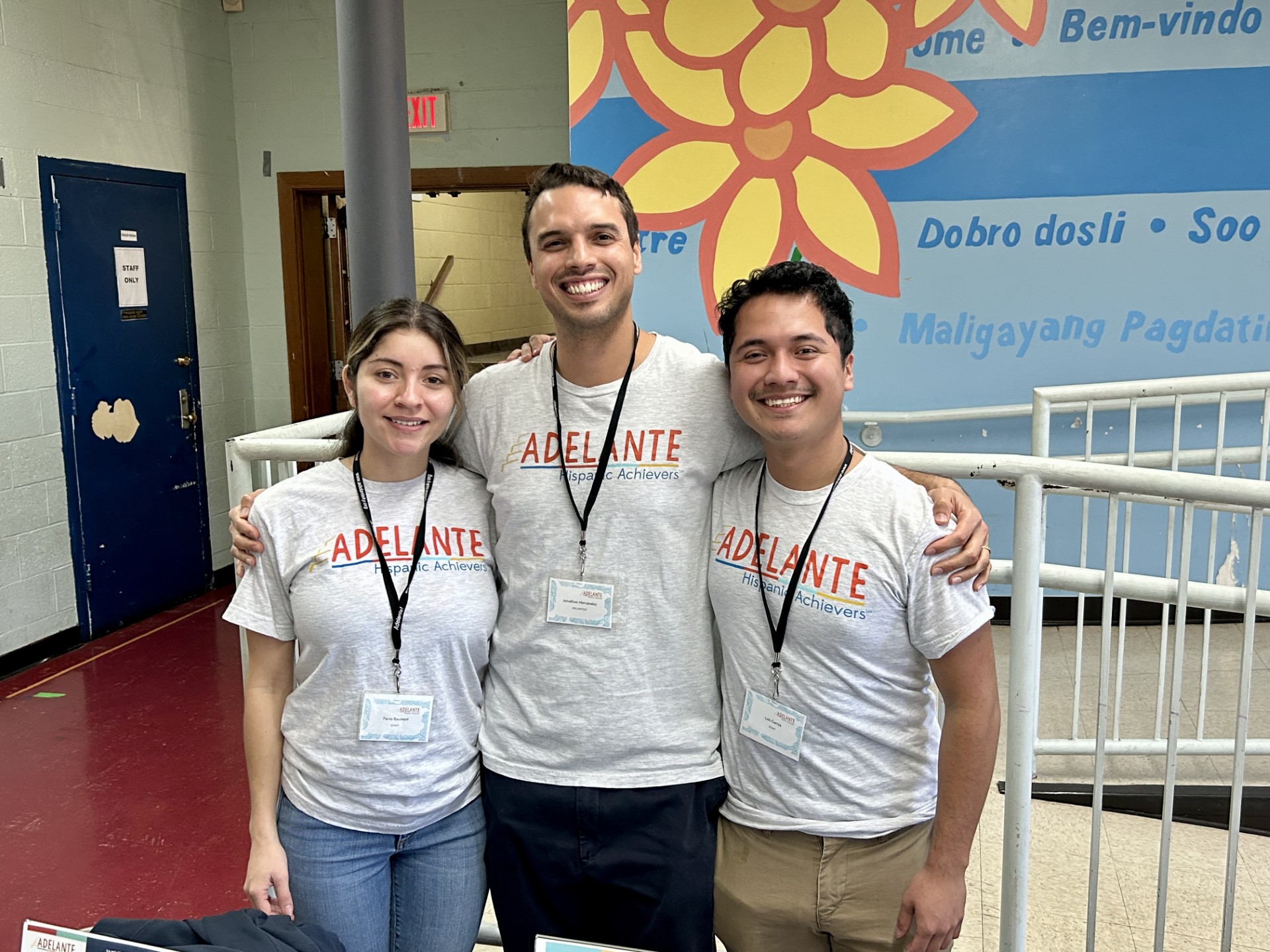 Three Adelante Hispanic Achievers (AHA) volunteers standing next to each other smiling. Adelante Latinx Hispanic youth mentoring program.